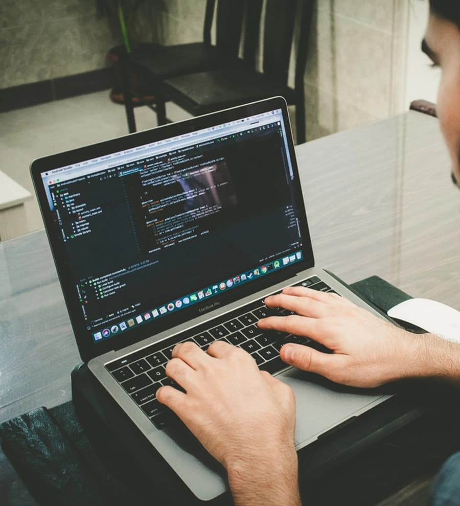 Developer working on a laptop with code on the screen