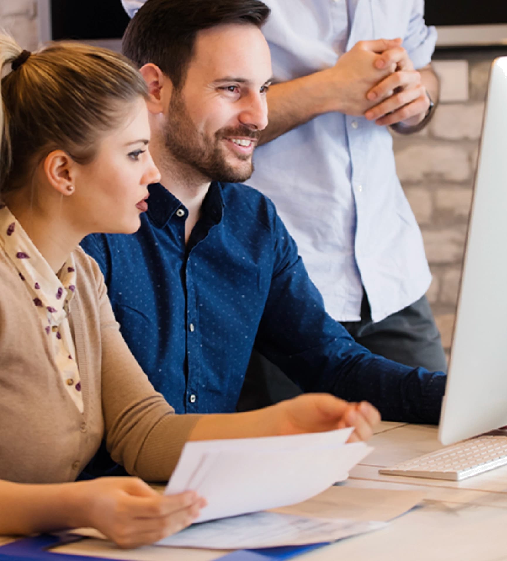 Male and female professional sitting down together at a desk reviewing a website.